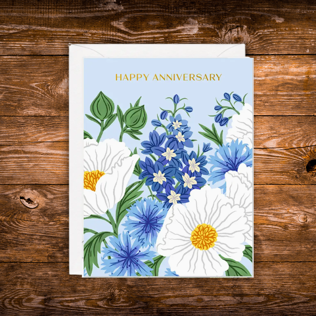 Floral anniversary greeting card featuring blue and white flowers on a soft blue background with the words "Happy Anniversary."