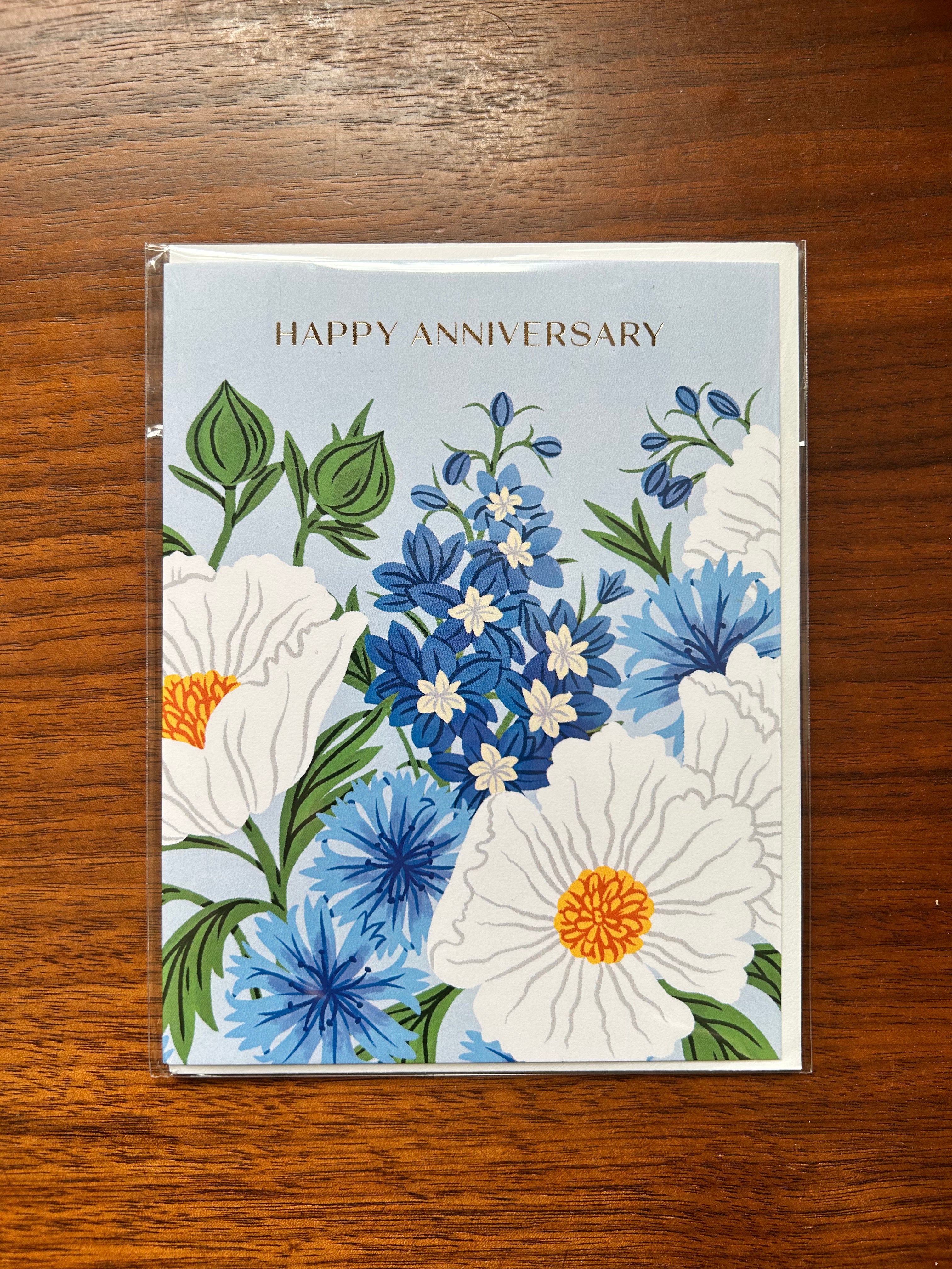 Floral anniversary greeting card featuring blue and white flowers on a soft blue background with the words "Happy Anniversary."