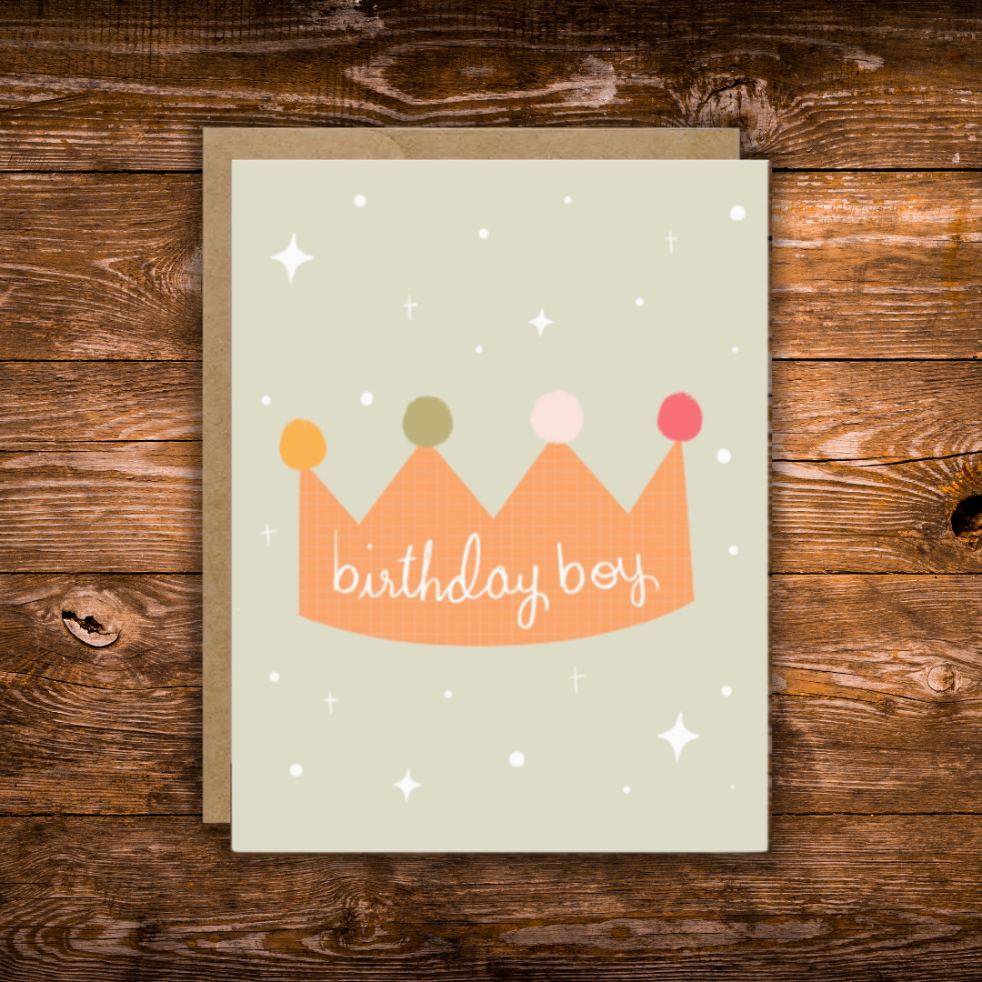 Cute birthday greeting card featuring a colorful illustrated crown with the words "Birthday Boy" on a soft sage green background with scattered stars.