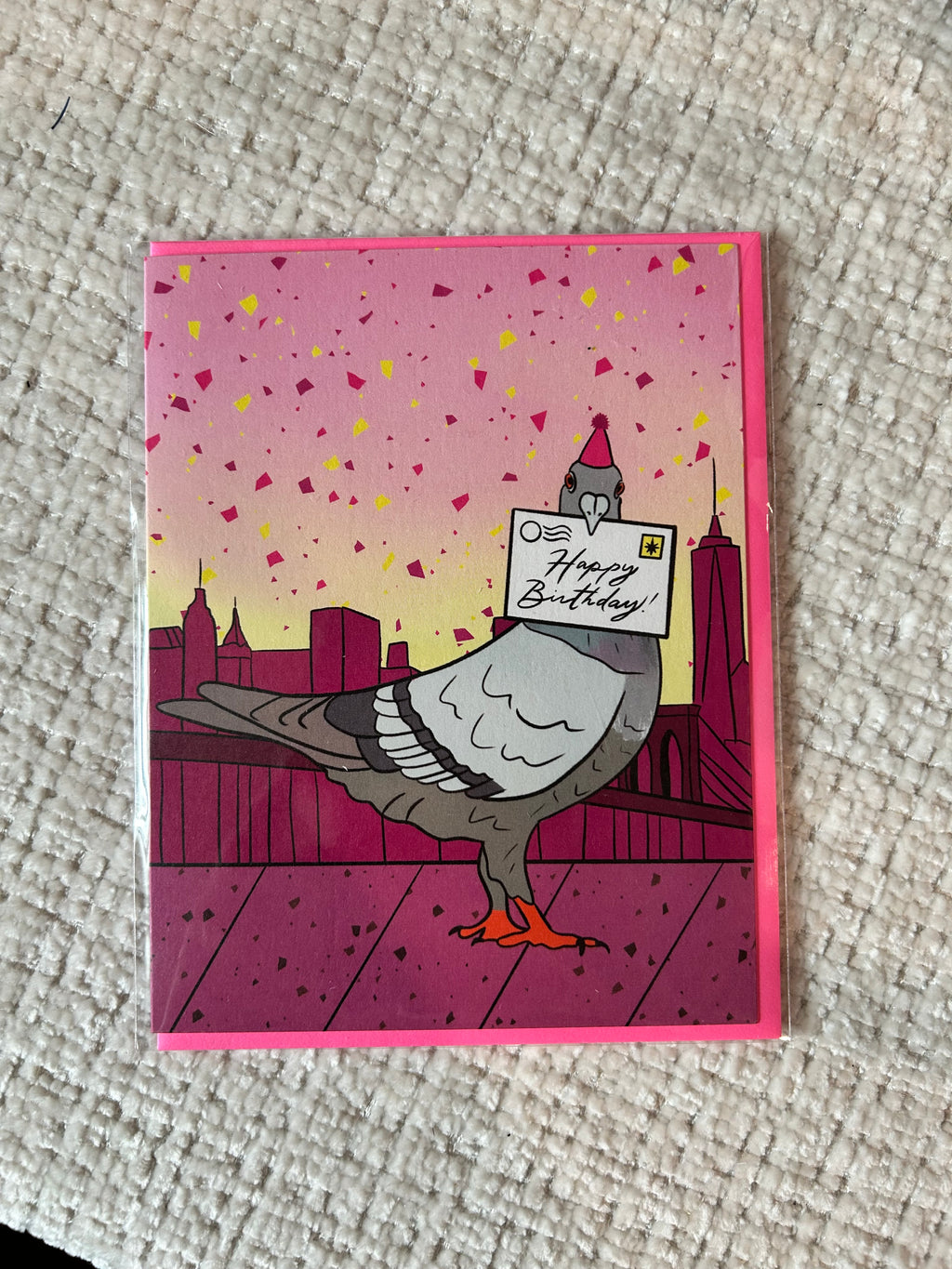 Birthday greeting card featuring a pigeon wearing a party hat and delivering a Happy Birthday letter with the New York City skyline in the background.