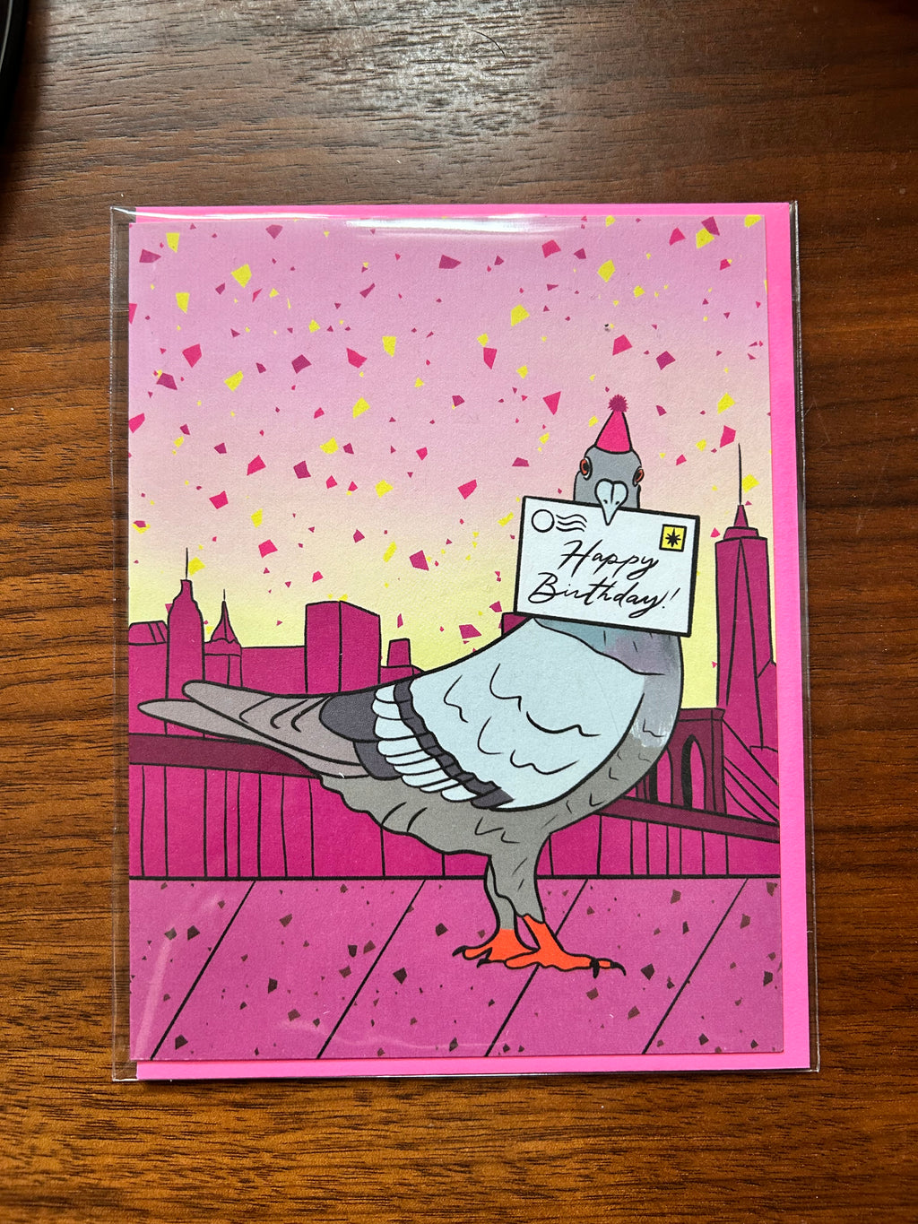 Birthday greeting card featuring a pigeon wearing a party hat and delivering a Happy Birthday letter with the New York City skyline in the background.