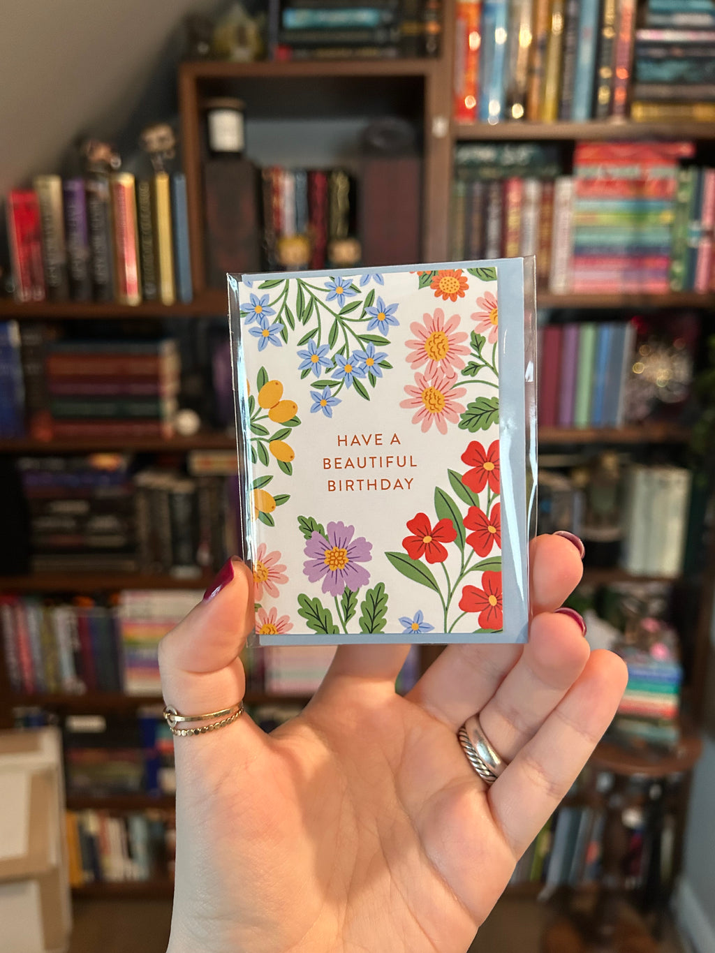 Mini birthday greeting card featuring colorful garden flowers surrounding the words "Have a Beautiful Birthday" on a white background.