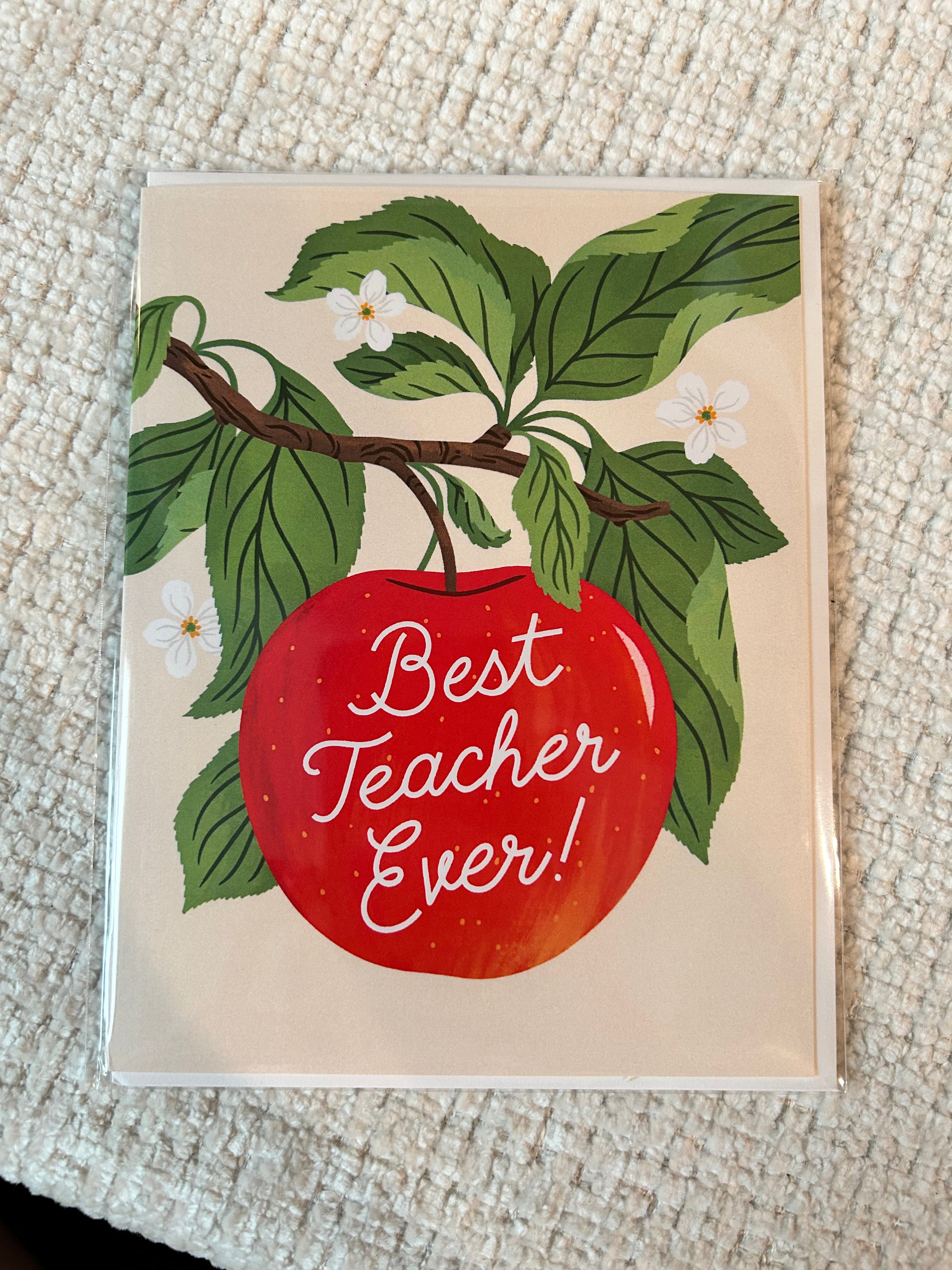 Teacher appreciation greeting card featuring a bright red apple hanging from a leafy branch with white blossoms and the words "Best Teacher Ever!" in white script.