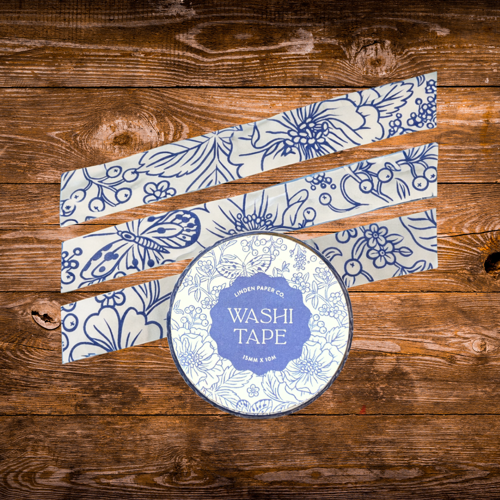 Decorative washi tape featuring blue botanical flowers, butterflies, berries, and leaves on a white background.