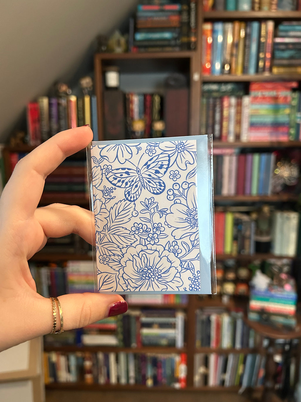 Mini greeting card featuring an elegant blue botanical illustration with flowers and a butterfly on a white background.
