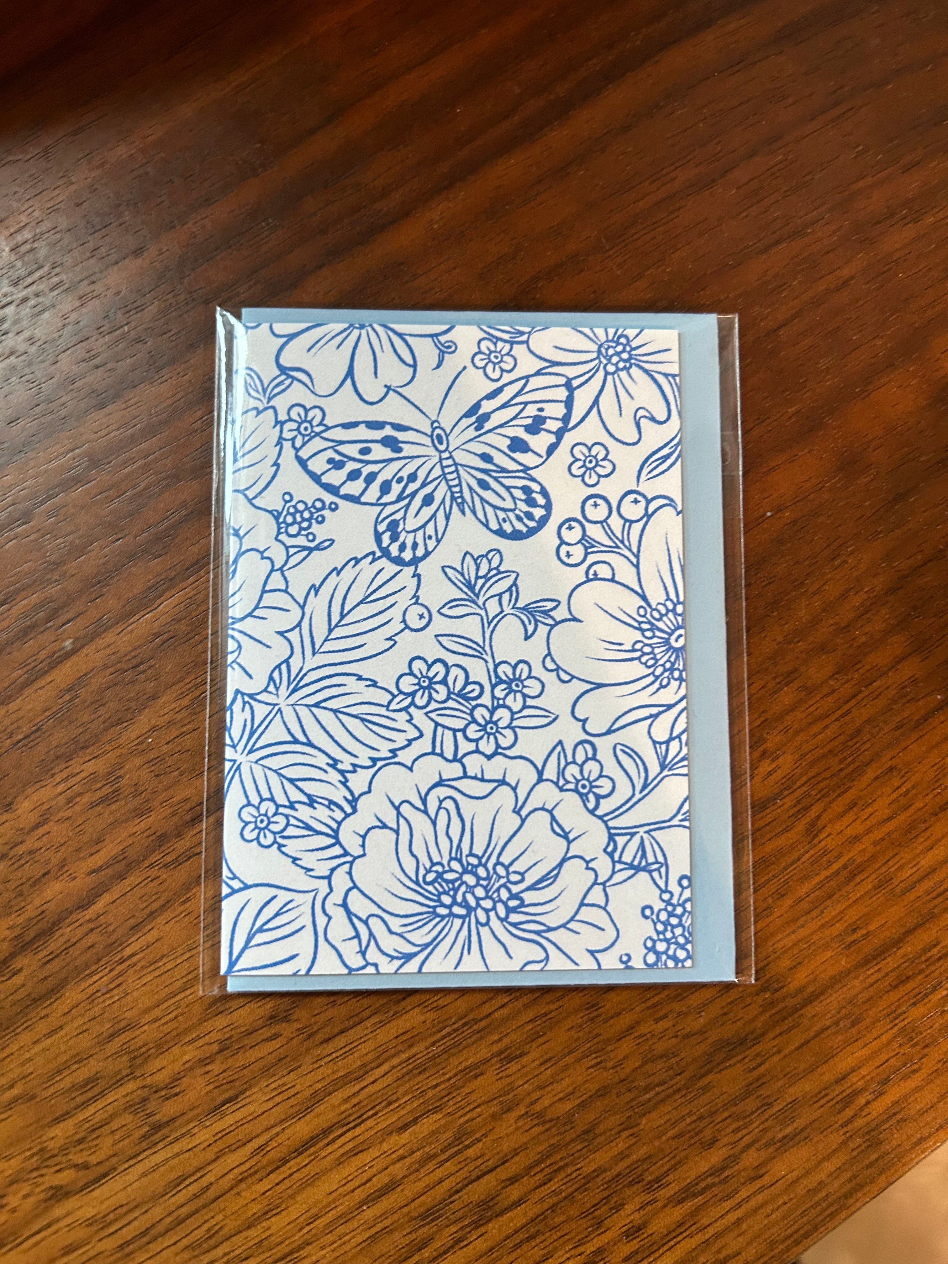 Mini greeting card featuring an elegant blue botanical illustration with flowers and a butterfly on a white background.