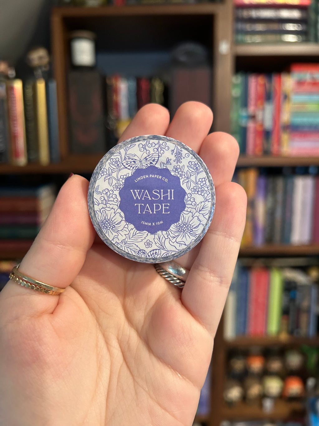 Decorative washi tape featuring blue botanical flowers, butterflies, berries, and leaves on a white background.