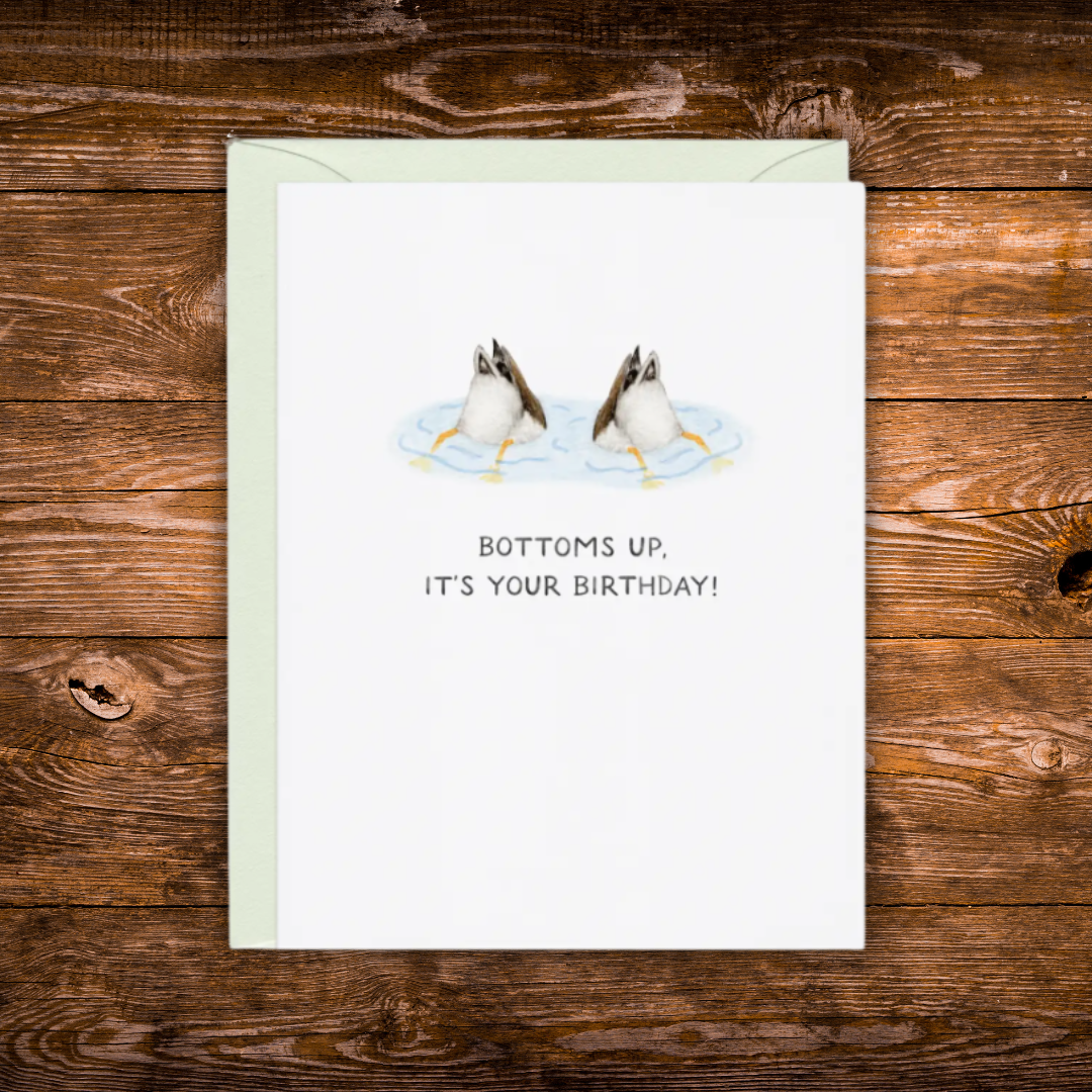 Birthday greeting card featuring two ducks diving underwater with the phrase "Bottoms Up, It's Your Birthday!"
