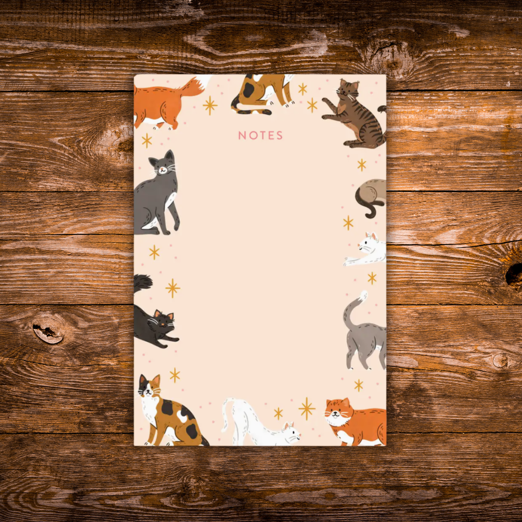 Tear-away notepad featuring playful illustrated cats around the border with an open center for writing notes.