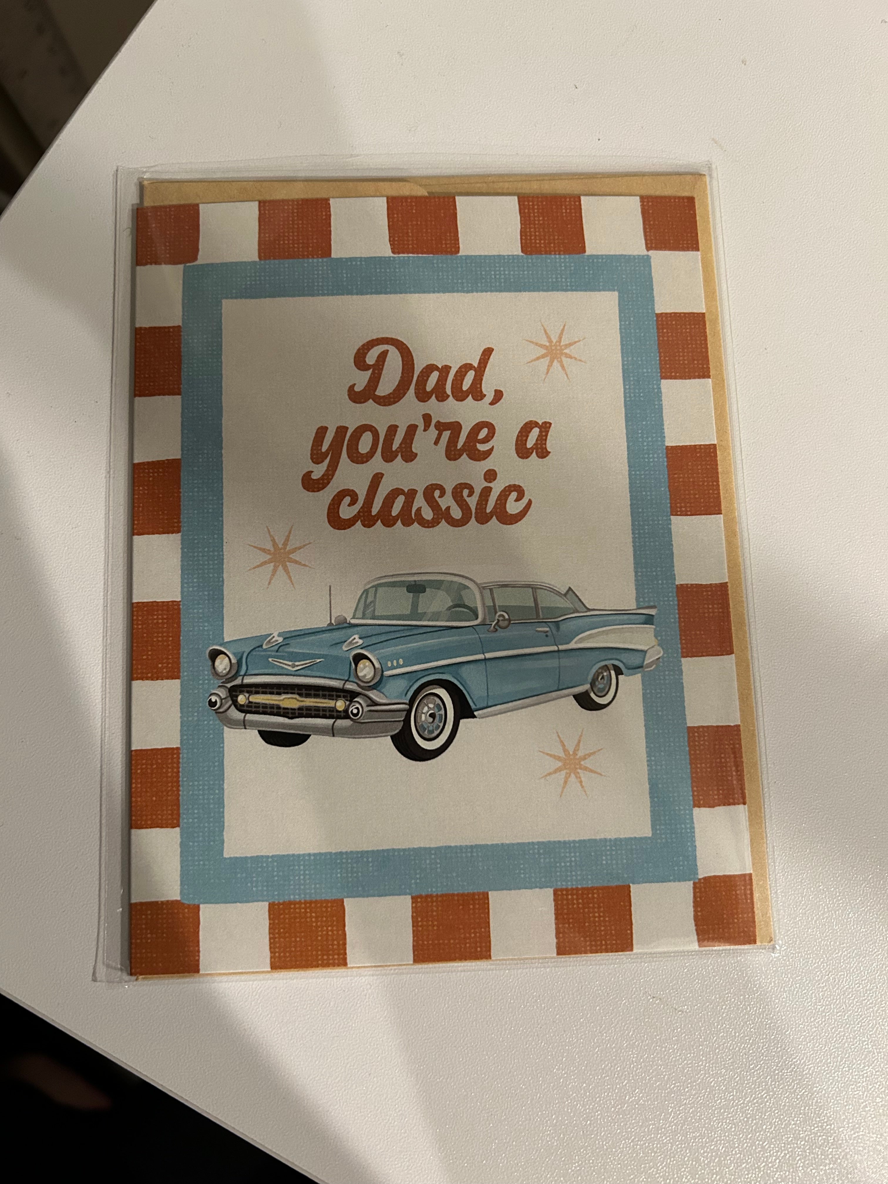 Father's Day greeting card featuring a vintage blue classic car with the message "Dad, You're a Classic" on a retro striped background.
