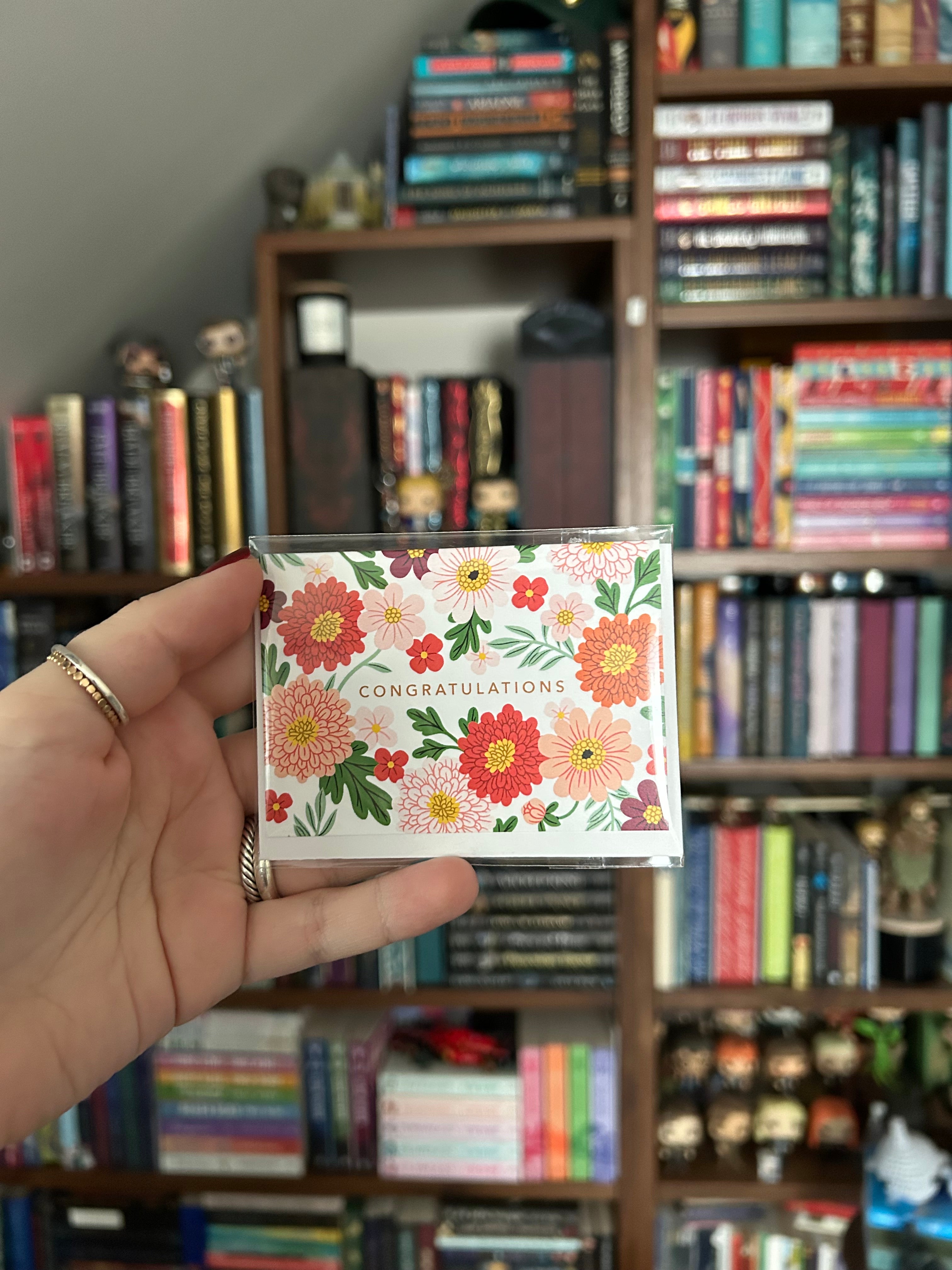 Mini landscape greeting card featuring colorful flowers surrounding the word "Congratulations" on a white background.