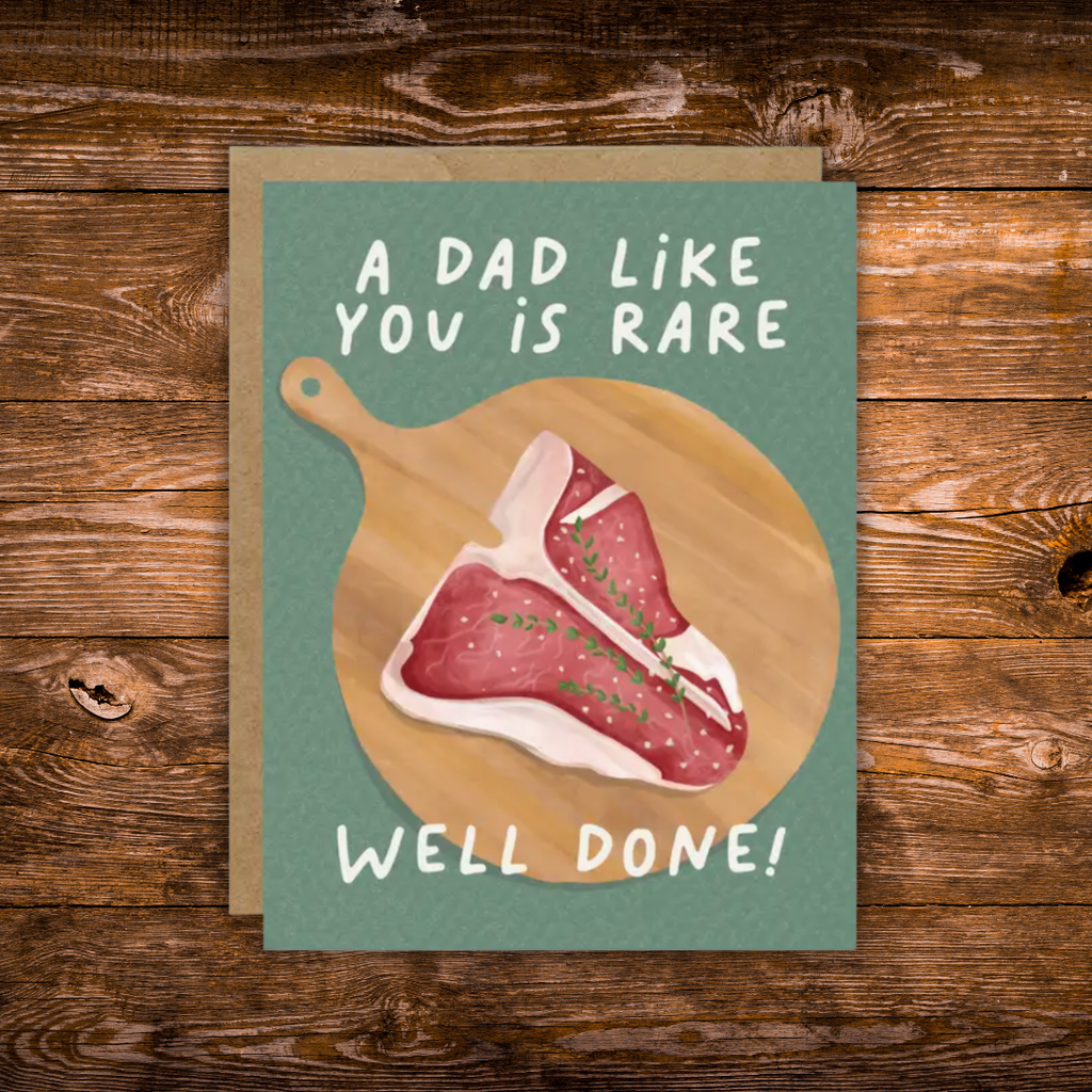 Funny Father's Day greeting card featuring an illustrated steak on a wooden cutting board with the message "A Dad Like You Is Rare. Well Done!"