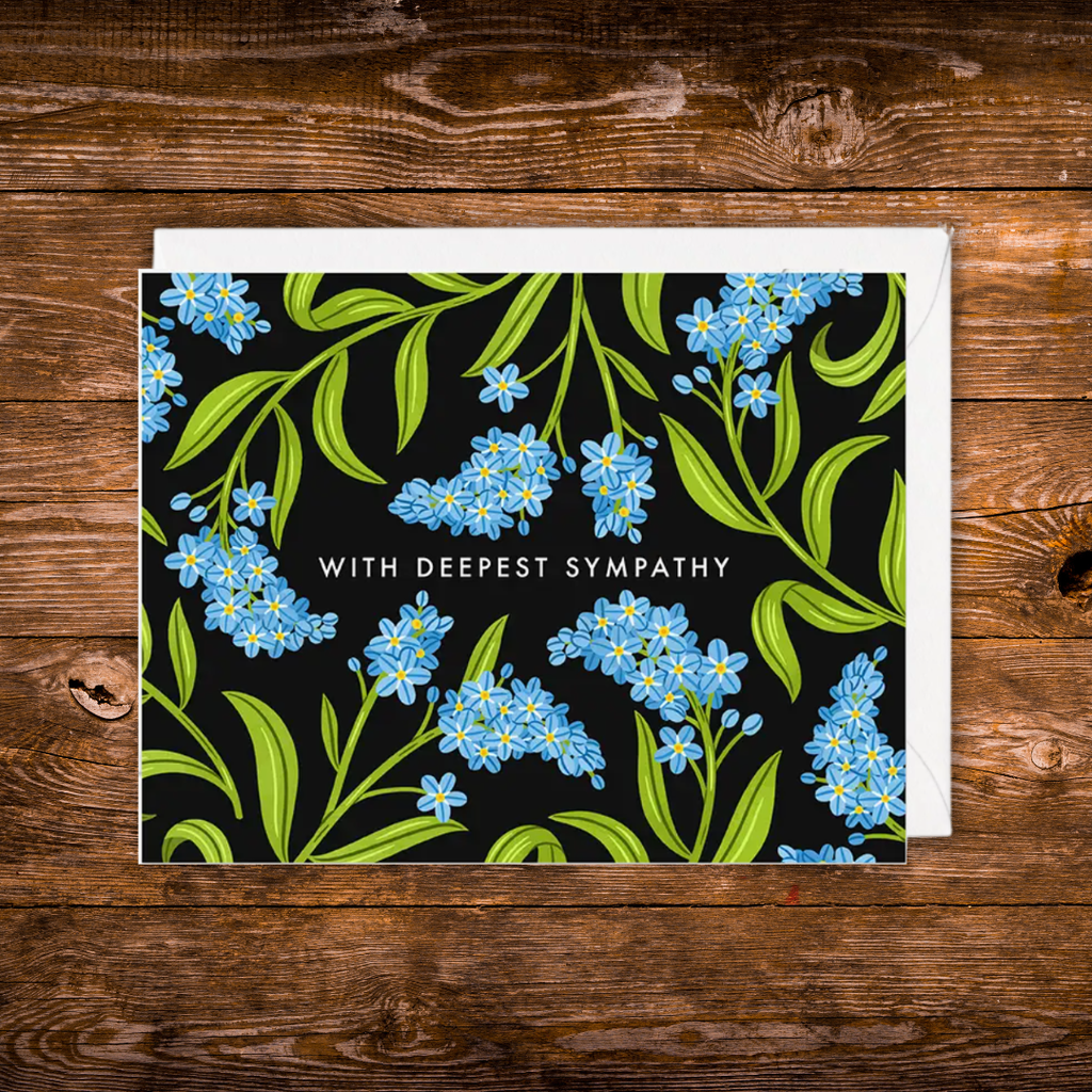 Landscape sympathy greeting card featuring blue forget-me-not flowers on a black background with the words "With Deepest Sympathy."