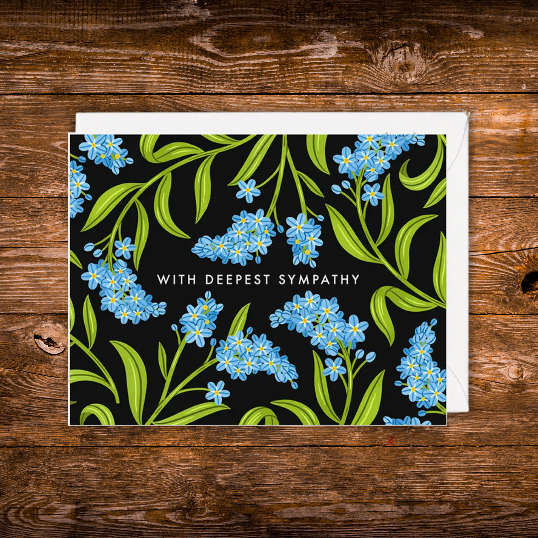 Landscape sympathy greeting card featuring blue forget-me-not flowers on a black background with the words "With Deepest Sympathy."
