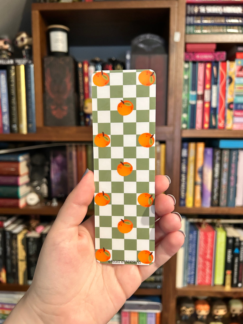 Double-sided bookmark featuring a white duck holding an orange and the phrase “You were on this page, dumbass,” with a green checkerboard and orange pattern on the reverse.