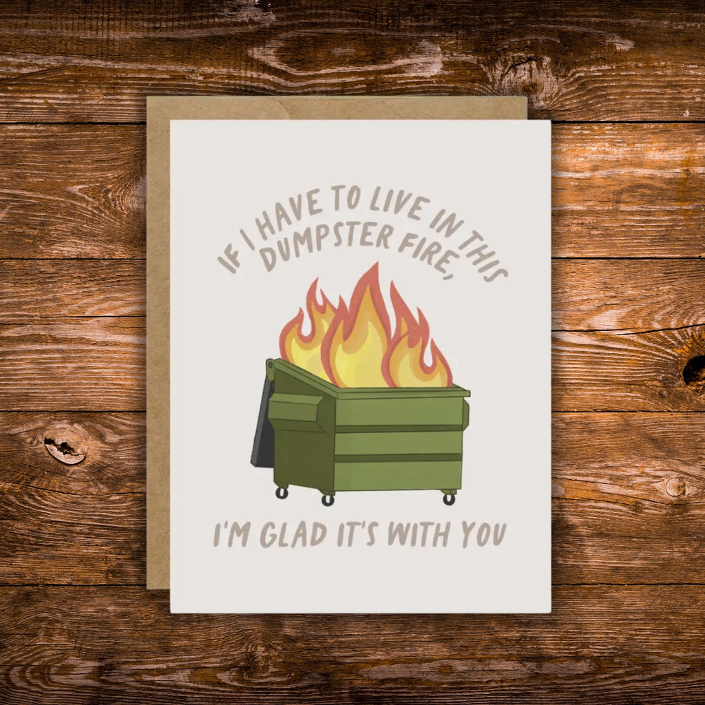 Funny greeting card featuring a flaming green dumpster with the message, "If I Have to Live in This Dumpster Fire, I'm Glad It's With You."