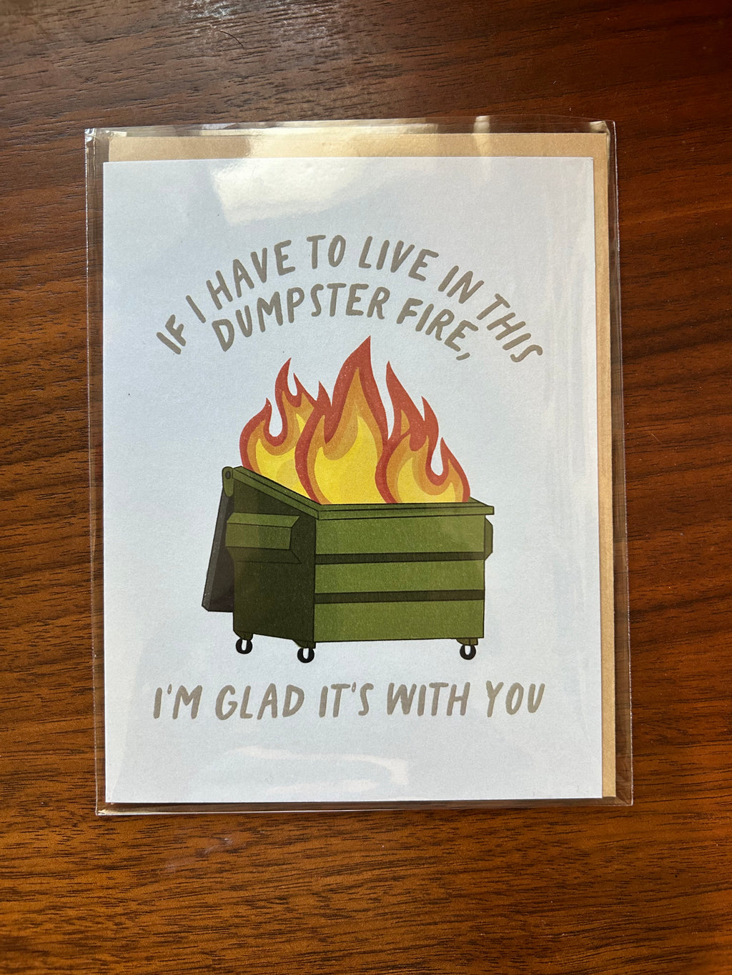Funny greeting card featuring a flaming green dumpster with the message, "If I Have to Live in This Dumpster Fire, I'm Glad It's With You."