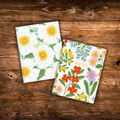 Set of two floral notebooks featuring colorful botanical cover designs with gold foil details, 44 blank pages each, and saddle stitched binding.