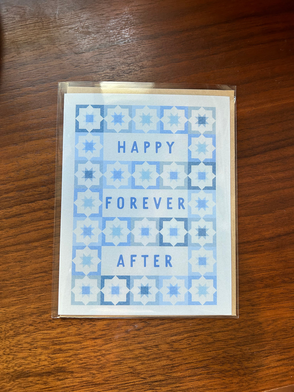 Modern wedding greeting card featuring the words "Happy Forever After" surrounded by a blue geometric tile pattern on a white background.