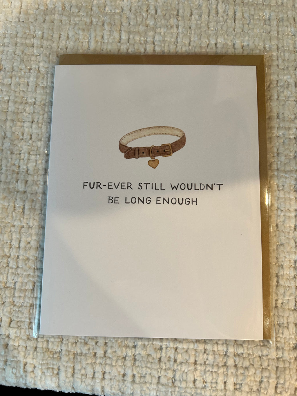 Minimalist pet sympathy greeting card featuring a brown pet collar with a heart-shaped tag and the message "Fur-Ever Still Wouldn't Be Long Enough" on a white background.