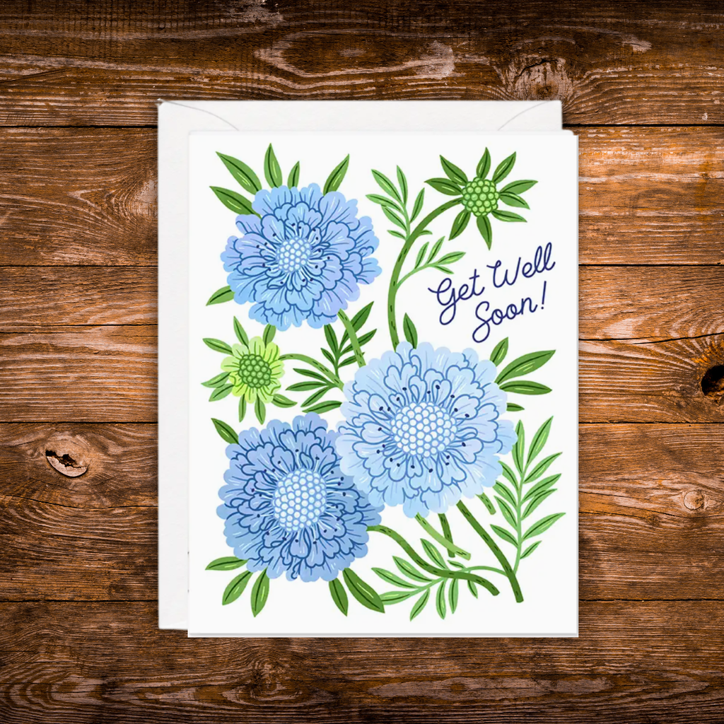 Blue floral Get Well Soon greeting card featuring illustrated flowers and greenery.