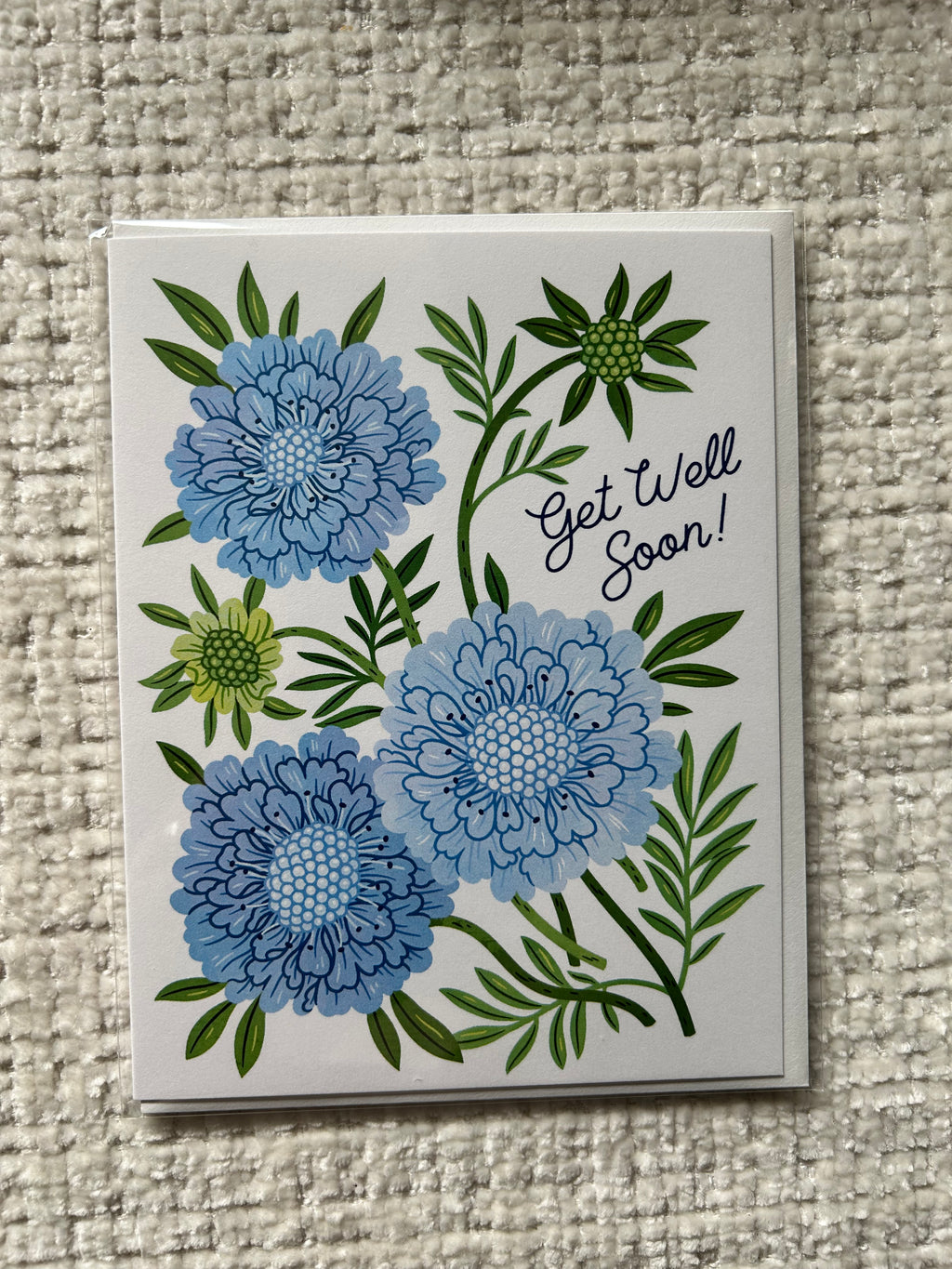 Blue floral Get Well Soon greeting card featuring illustrated flowers and greenery.