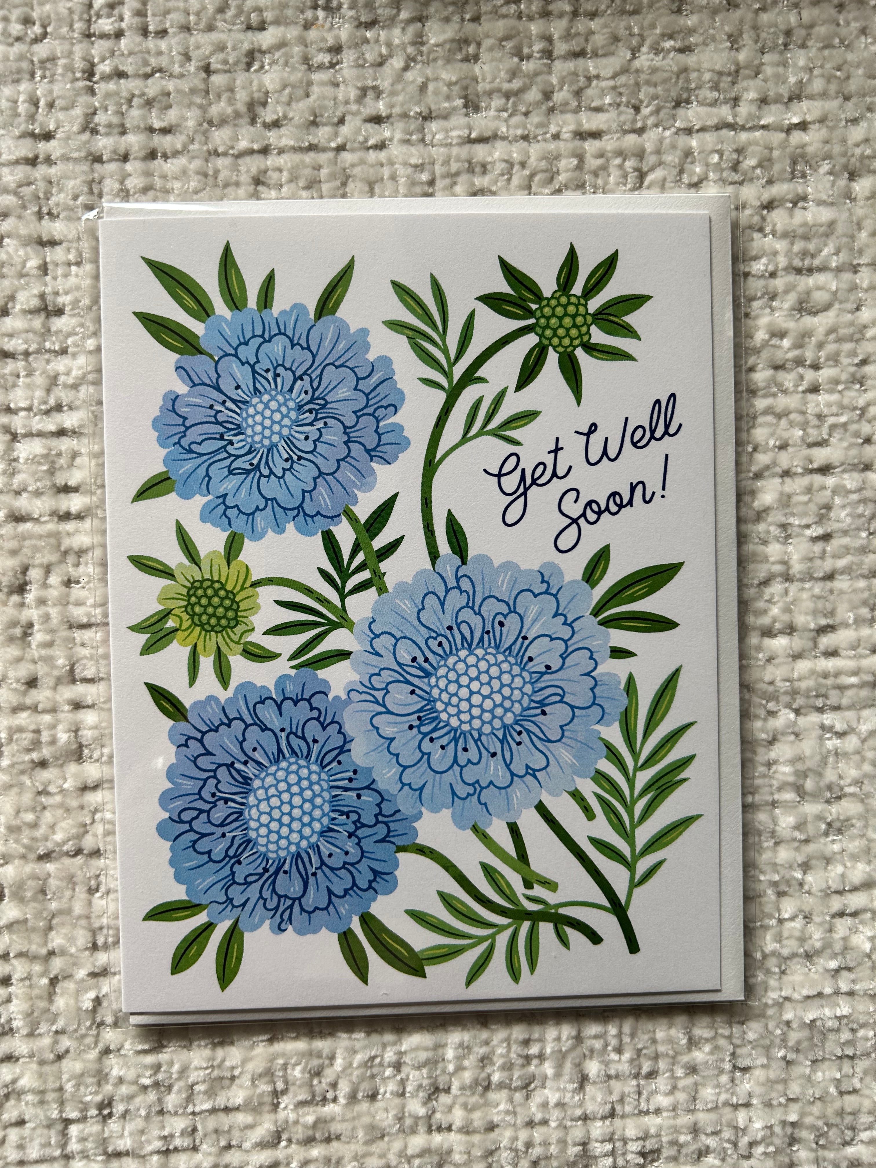Blue floral Get Well Soon greeting card featuring illustrated flowers and greenery.
