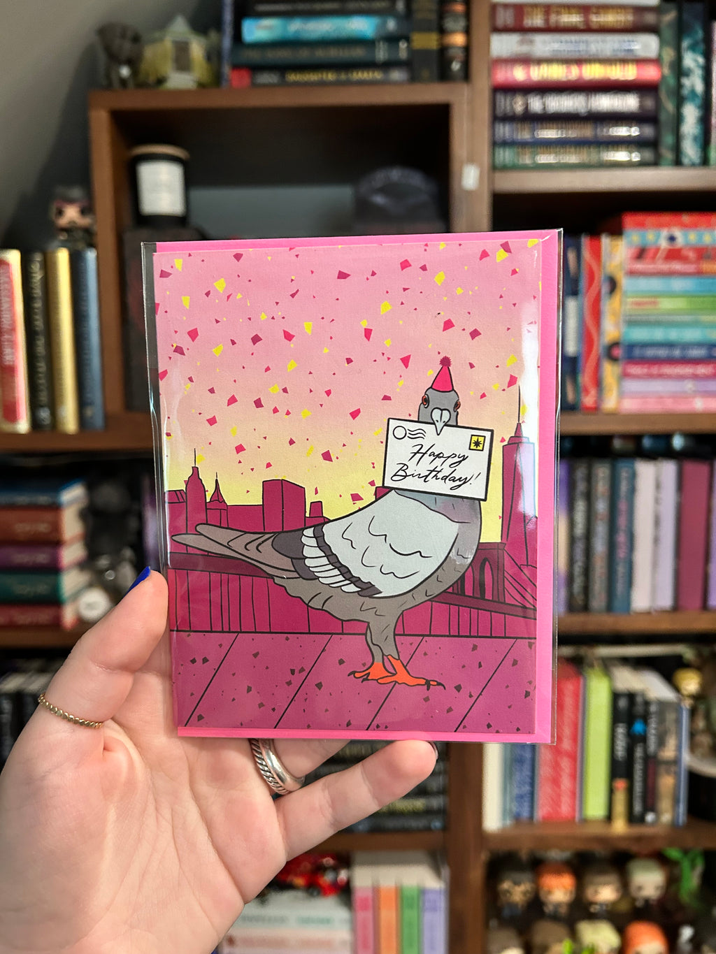 Birthday greeting card featuring a pigeon wearing a party hat and delivering a Happy Birthday letter with the New York City skyline in the background.