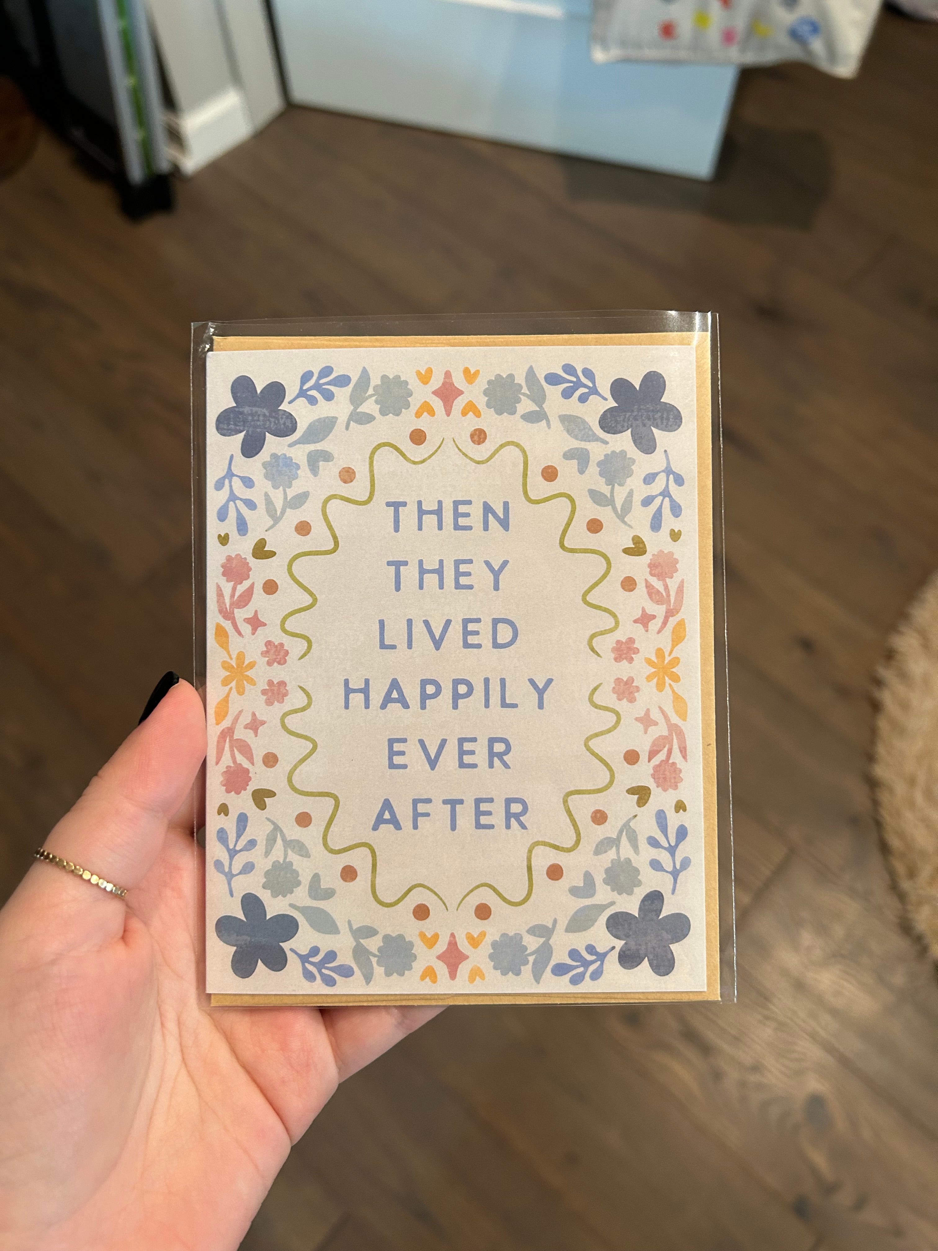 Pastel floral wedding greeting card featuring the phrase "Then They Lived Happily Ever After" surrounded by a colorful floral border.