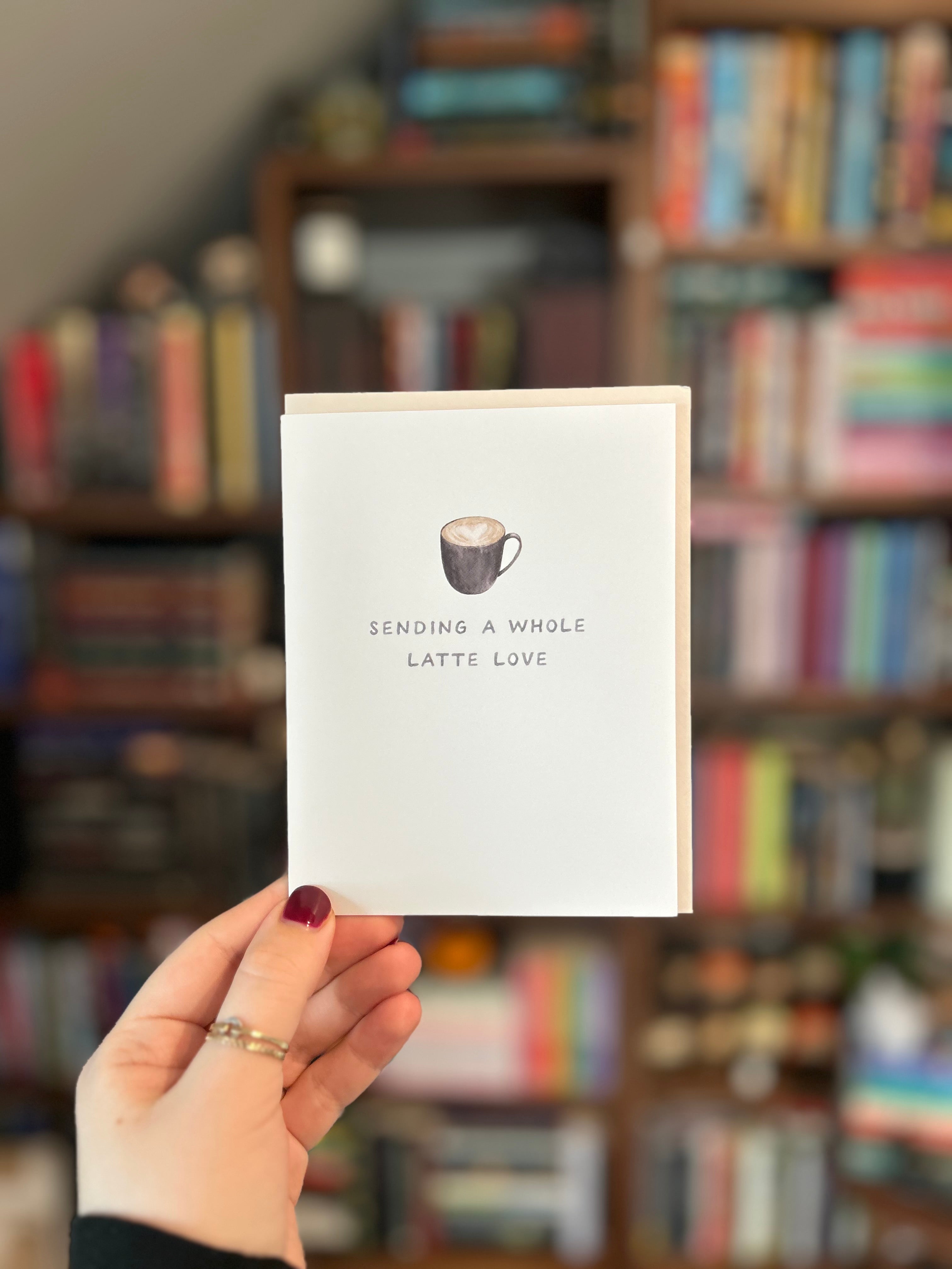 Minimalist greeting card featuring a latte with heart latte art and the phrase "Sending a Whole Latte Love."