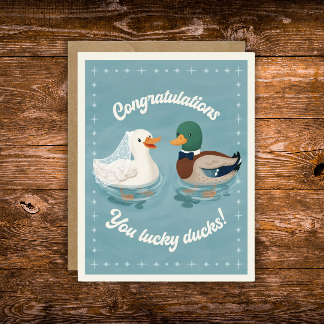 Wedding congratulations greeting card featuring a bride duck wearing a veil and a groom duck wearing a bow tie with the phrase "Congratulations You Lucky Ducks!"