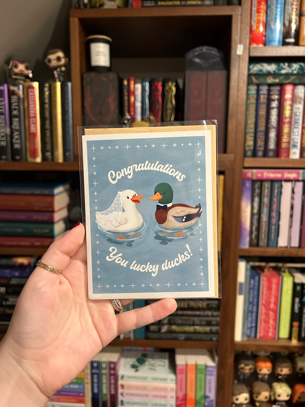 Wedding congratulations greeting card featuring a bride duck wearing a veil and a groom duck wearing a bow tie with the phrase "Congratulations You Lucky Ducks!"