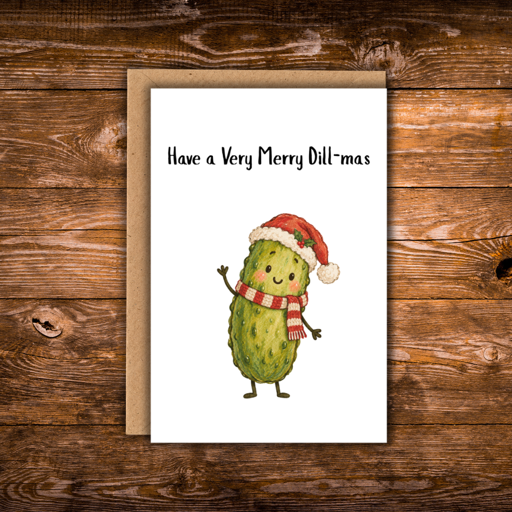 Christmas greeting card featuring a smiling green pickle wearing a Santa hat and red-and-white scarf with the phrase “Have a Very Merry Dill-mas.” 