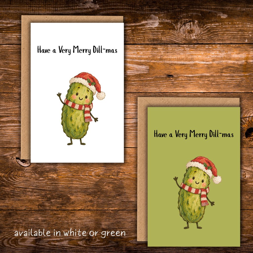 Christmas greeting card featuring a smiling green pickle wearing a Santa hat and red-and-white scarf with the phrase “Have a Very Merry Dill-mas.” Available with a white or olive-green background and a kraft envelope.
