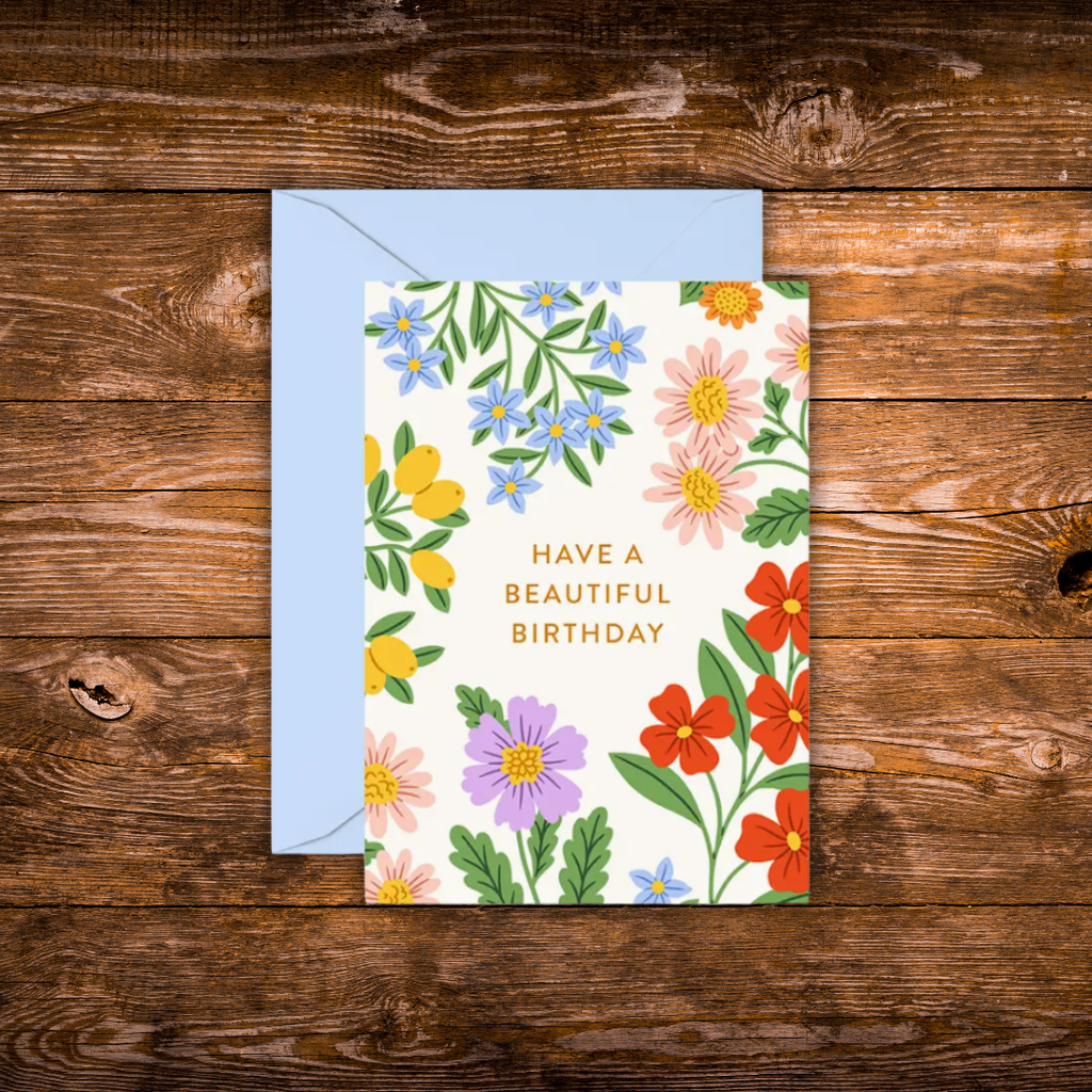 Mini birthday greeting card featuring colorful garden flowers surrounding the words "Have a Beautiful Birthday" on a white background.