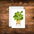 Mini greeting card featuring a green houseplant in a decorative yellow planter with the words "many thanks" beneath it on a white background.