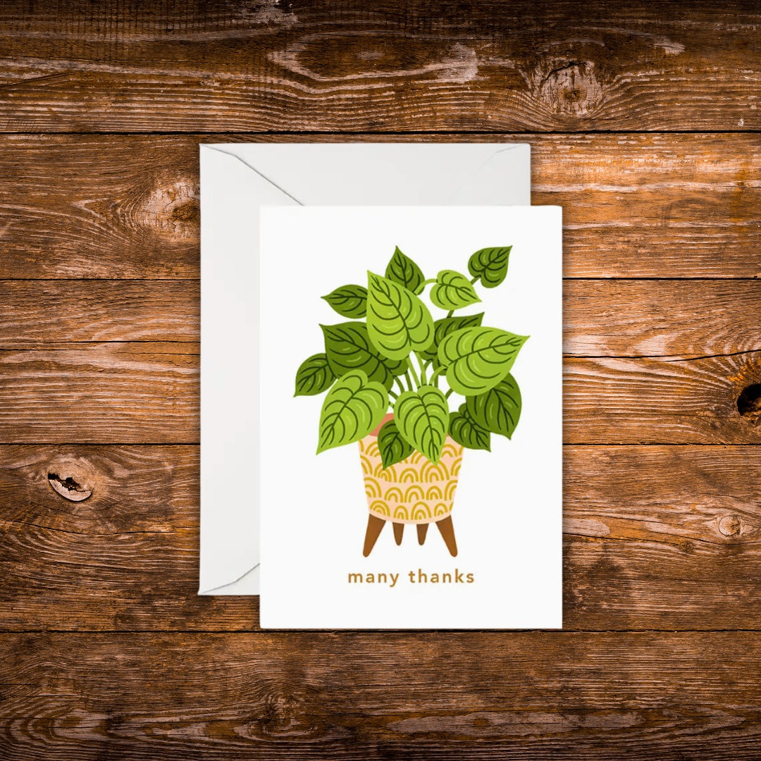 Mini greeting card featuring a green houseplant in a decorative yellow planter with the words "many thanks" beneath it on a white background.
