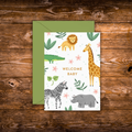 Mini greeting card featuring adorable safari animals including a lion, giraffe, zebra, rhinoceros, and crocodile surrounding the words "Welcome Baby."