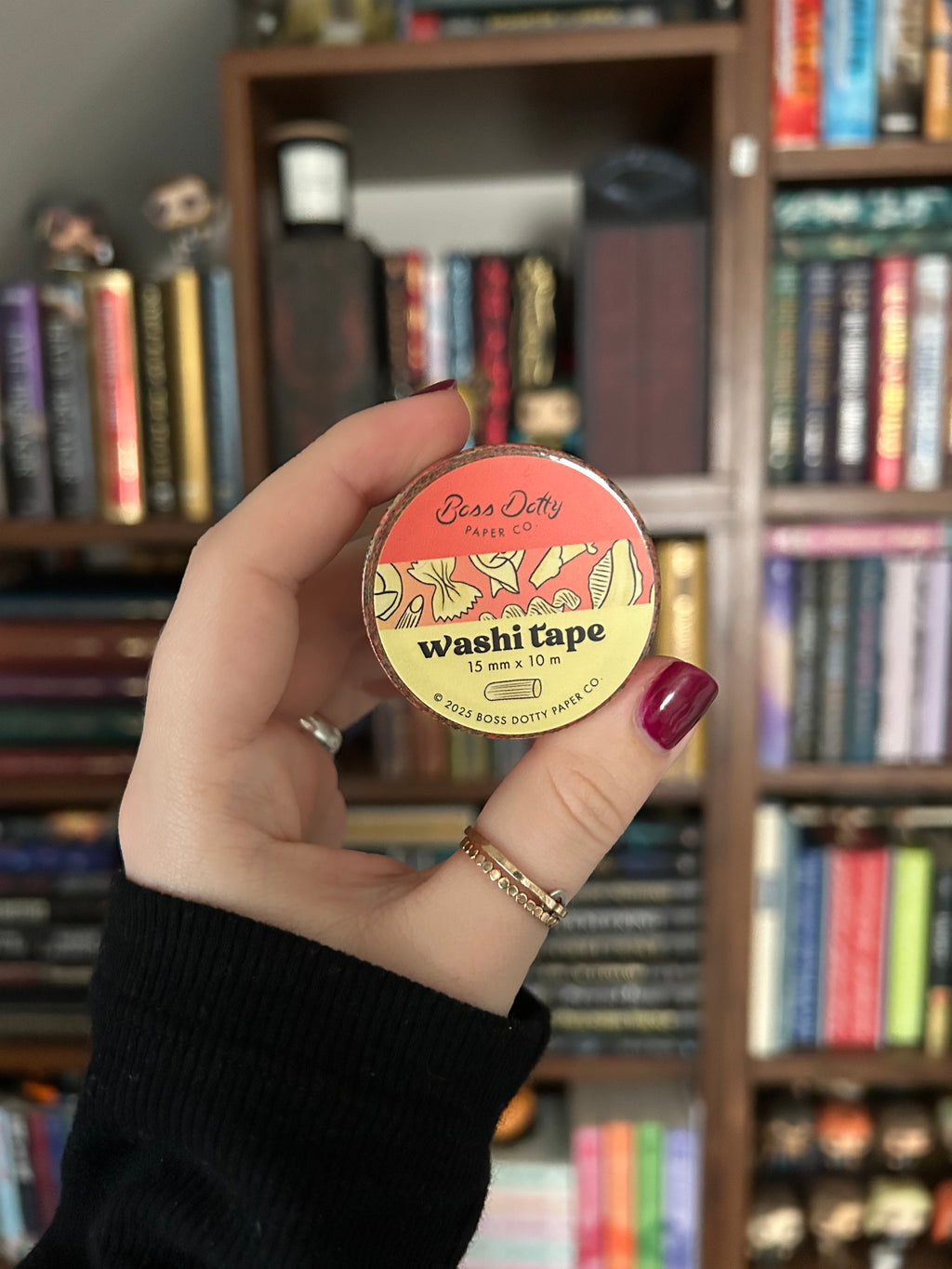 Decorative washi tape featuring illustrated pasta shapes including ravioli, rigatoni, fusilli, shells, and farfalle on a red background.