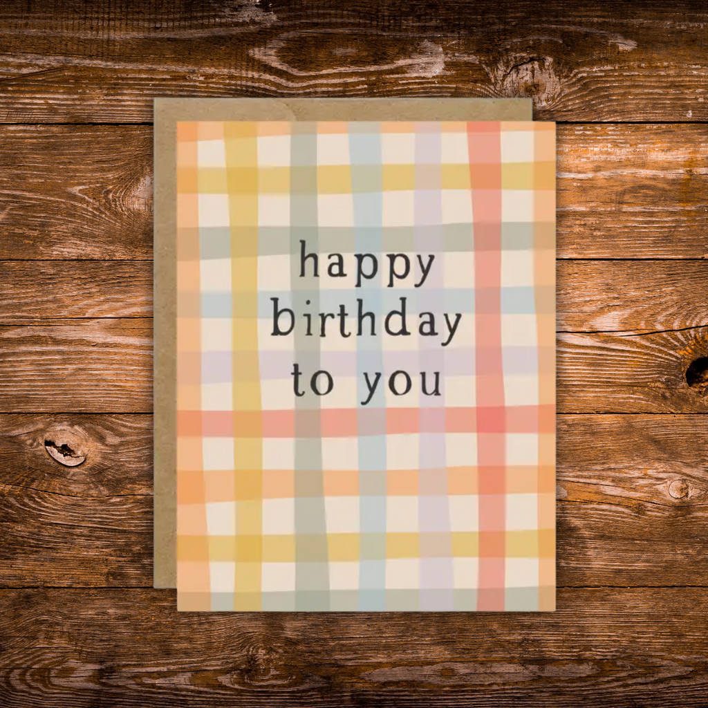 Modern birthday greeting card featuring a soft pastel plaid pattern with the message "Happy Birthday to You" in minimalist black typography.
