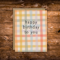 Modern birthday greeting card featuring a soft pastel plaid pattern with the message "Happy Birthday to You" in minimalist black typography.