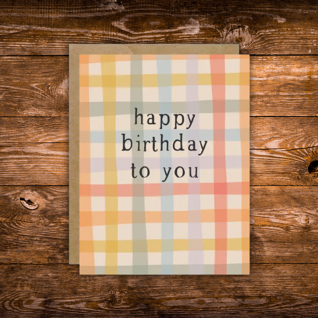 Modern birthday greeting card featuring a soft pastel plaid pattern with the message "Happy Birthday to You" in minimalist black typography.