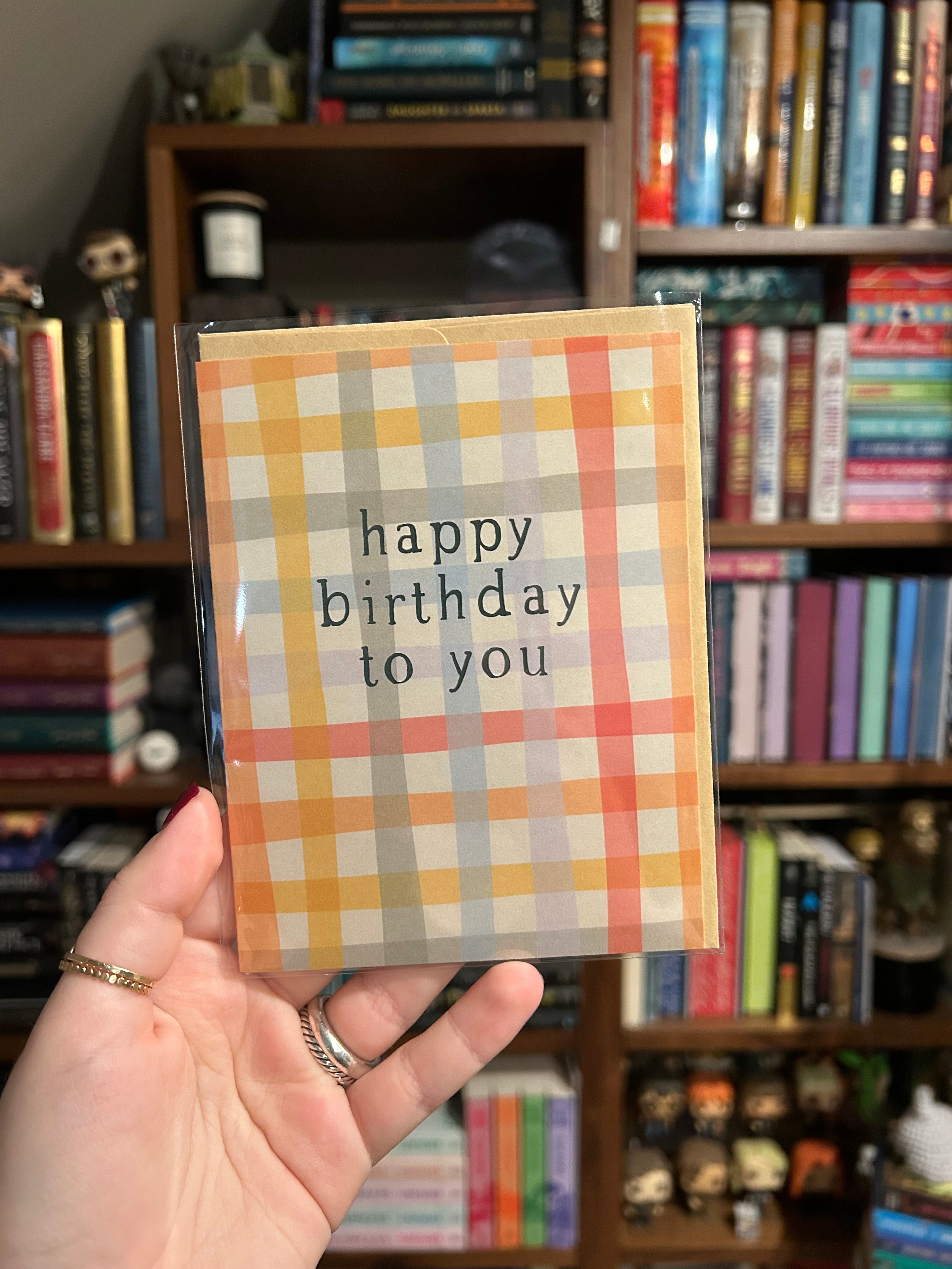 Modern birthday greeting card featuring a soft pastel plaid pattern with the message "Happy Birthday to You" in minimalist black typography.