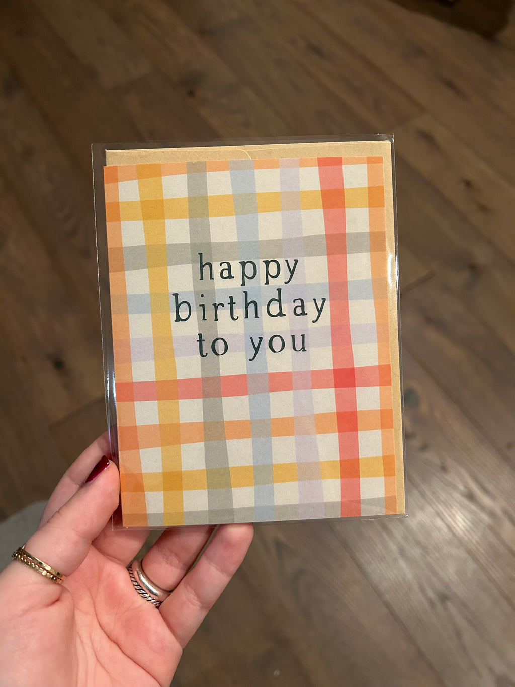Modern birthday greeting card featuring a soft pastel plaid pattern with the message "Happy Birthday to You" in minimalist black typography.