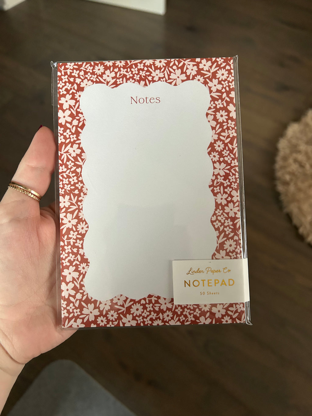Floral notepad featuring a coral-red background with a delicate white flower border and a scalloped writing area labeled "Notes."