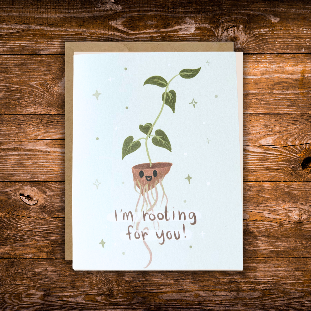 Cute encouragement greeting card featuring a smiling houseplant with exposed roots and the message "I'm Rooting for You!" on a soft blue background. 