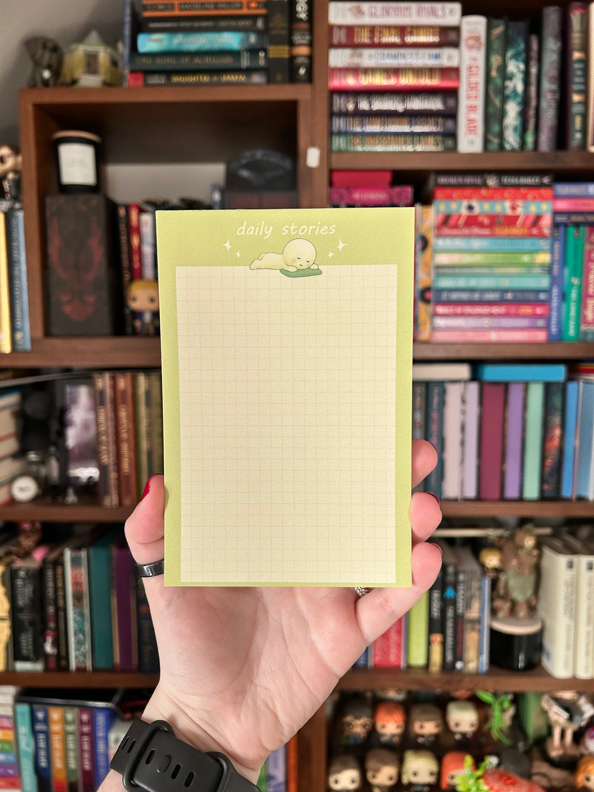 Green Smiski-inspired notepad with a cute lounging character and light grid writing paper
