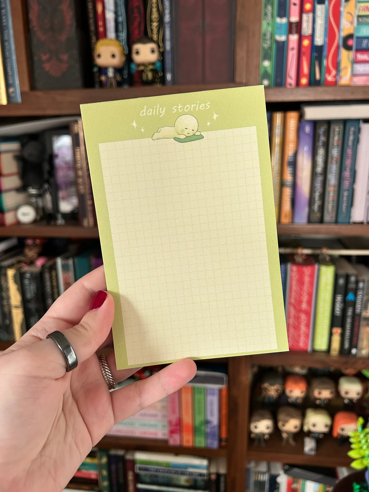 Green Smiski-inspired notepad with a cute lounging character and light grid writing paper