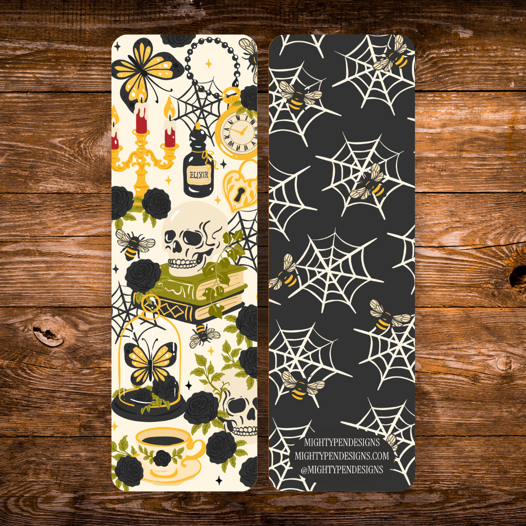 Double-sided gothic bookmark with skulls, black roses, candles, potion bottles, and golden accents on a cream background, paired with a black reverse featuring cream spiderwebs and golden bees.