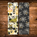 Double-sided gothic bookmark with skulls, black roses, candles, potion bottles, and golden accents on a cream background, paired with a black reverse featuring cream spiderwebs and golden bees.